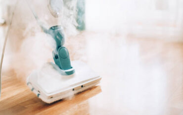 Steam cleaner mop cleaining floor. Banner with copy space. Cleaning service concept.